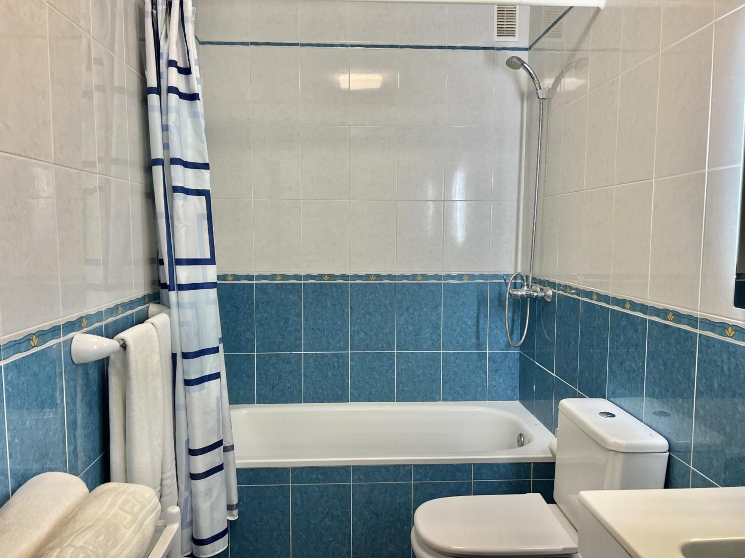 A bathroom with a bathtub, toilet, and shower.