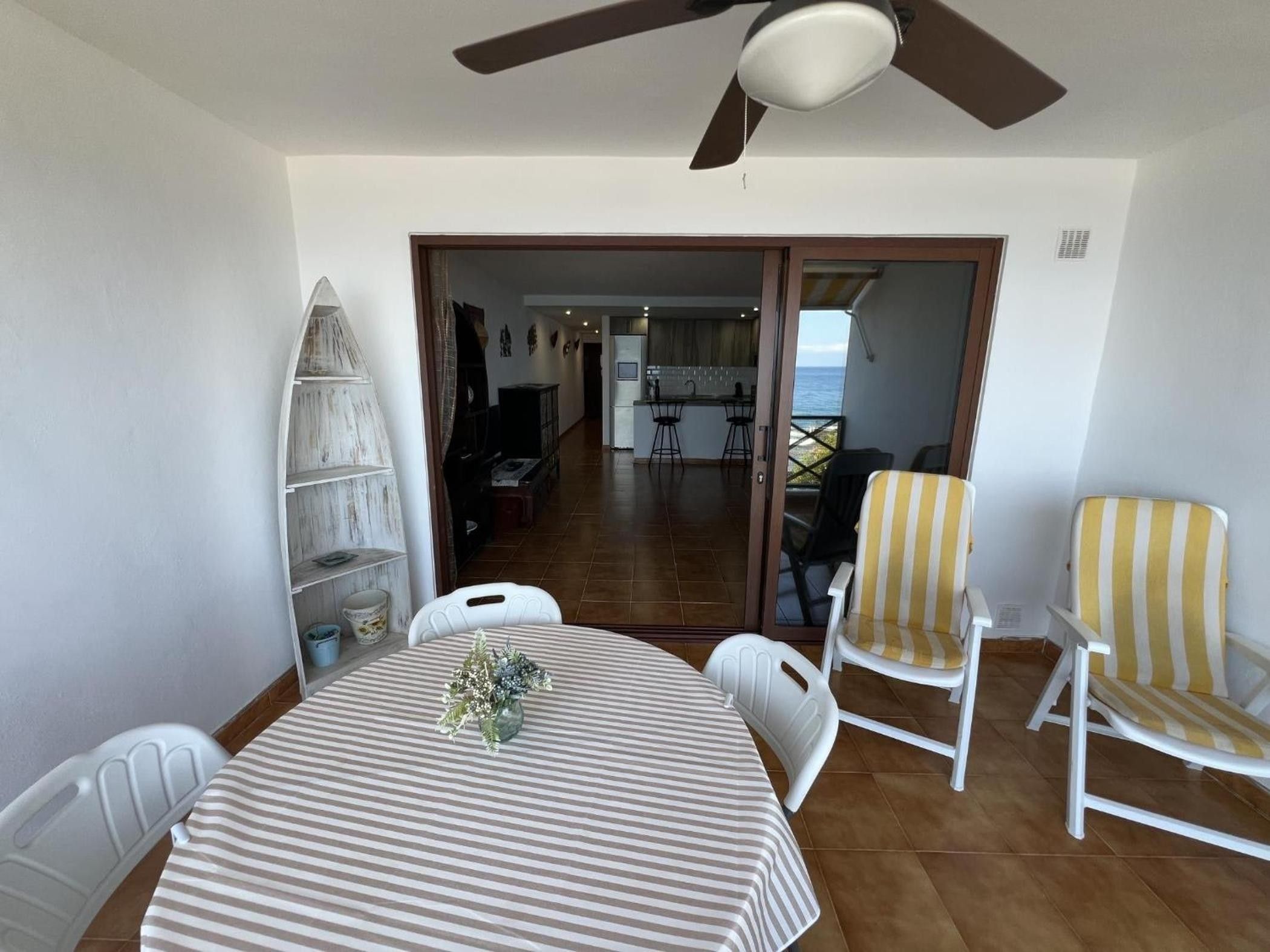 Un comedor con una mesa, sillas y un ventilador de techo.
