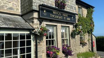 A stone building with a sign that reads 'WHOD HAVE THOUGHT IT INN' and 'S. AUSTELL ALES'.