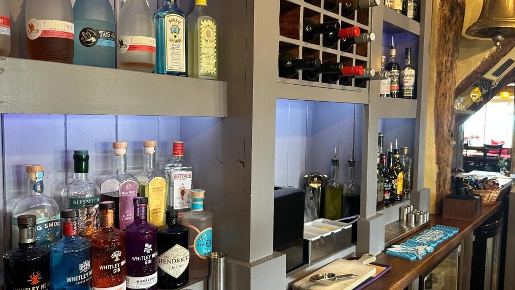 A bar area with various liquor bottles and a wine rack.