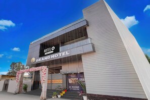 A hotel with a sign reading 'GRAND HOTEL' and 'HOTEL OYO-Serviced'.