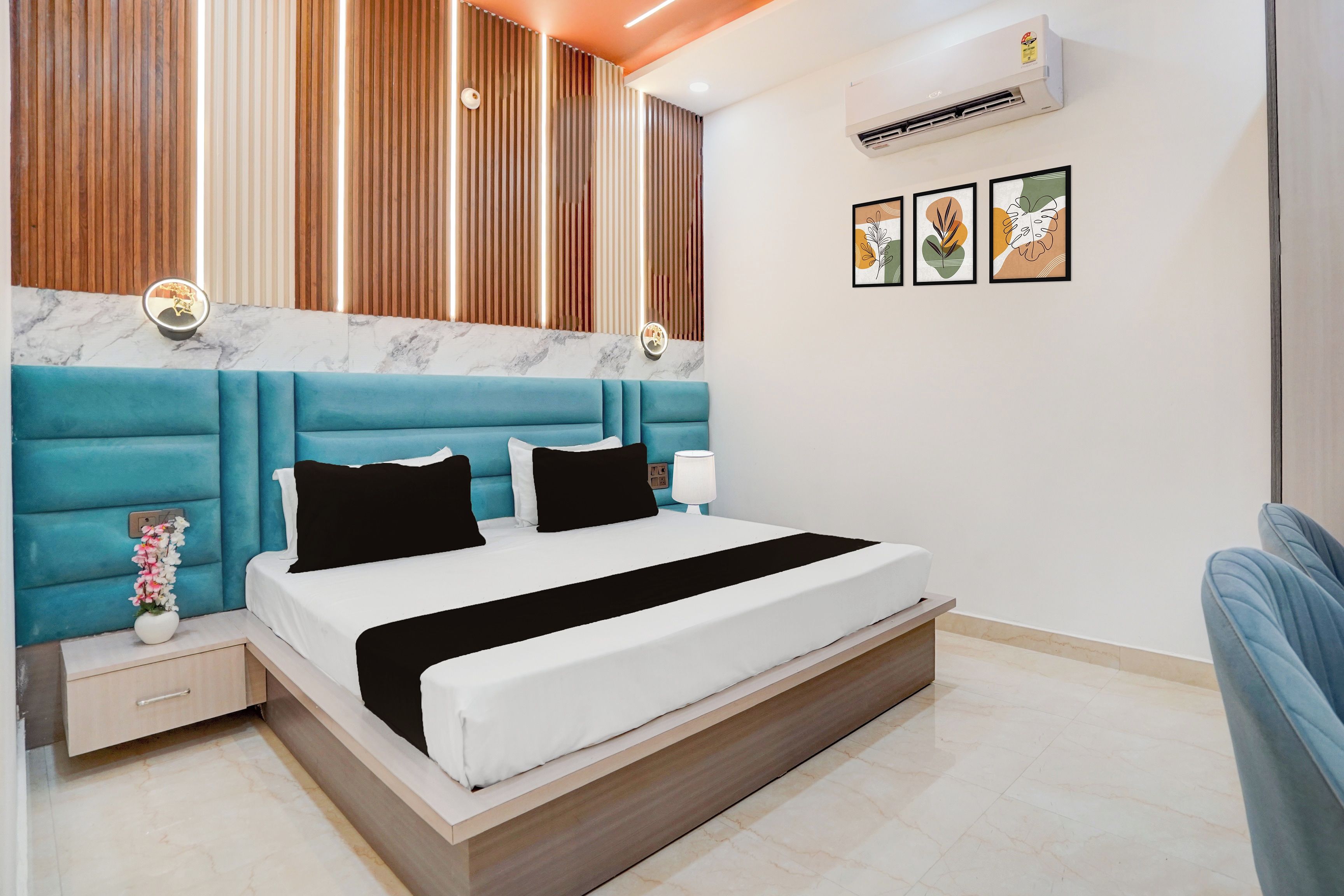 Un dormitorio moderno con una cama grande, cabecera de madera, pared de acento de mármol y aire acondicionado de pared.