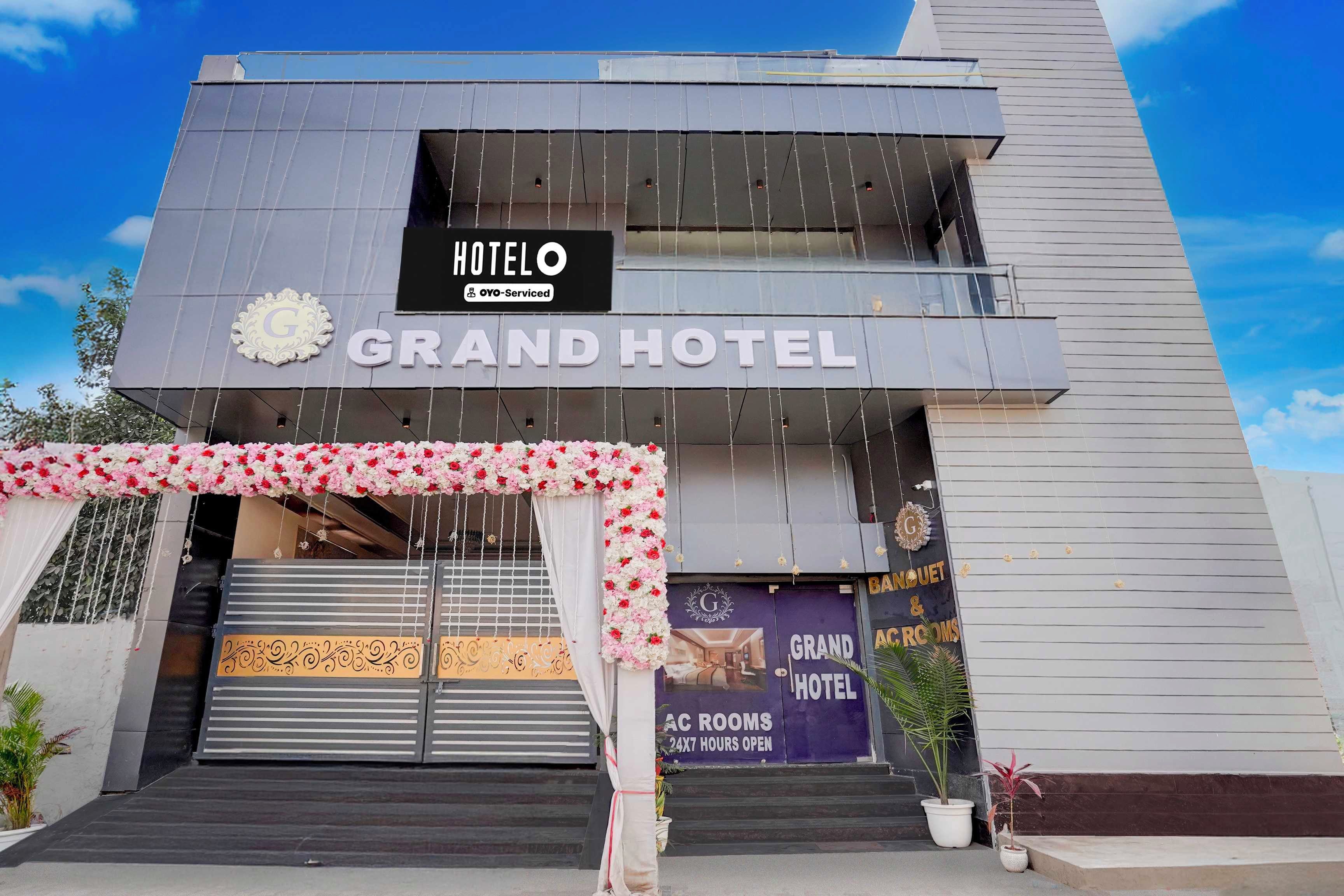 En hotellentrén med en skylt där det står ”HOTEL O GRAND HOTEL” och en banderoll som annonserar ”AC-RUM, ÖPPET DYGNET RUNT”.