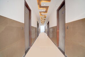 Corredor com portas indicando os números 105 e 106, que dá acesso a um interior iluminado.