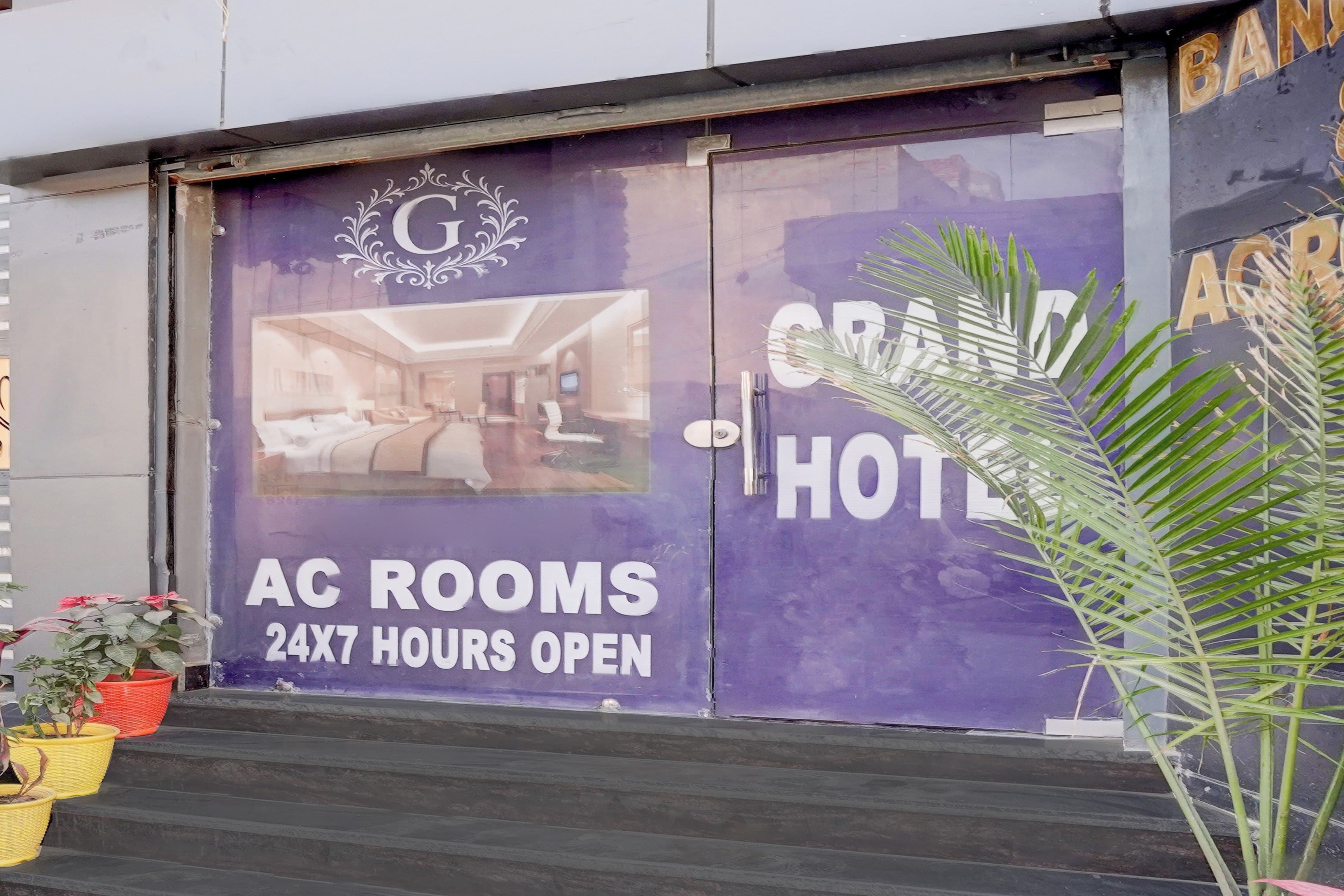 Entrada de hotel con un letrero que anuncia habitaciones con aire acondicionado, abierta las 24 horas y vistas al interior.