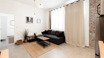 Una sala de estar moderna con sofá, mesa de centro y planta en maceta.