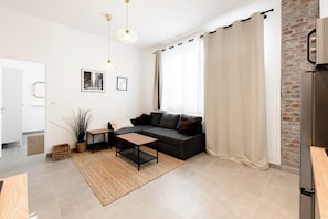 Un salon moderne avec un canapé, une table basse et une plante en pot.