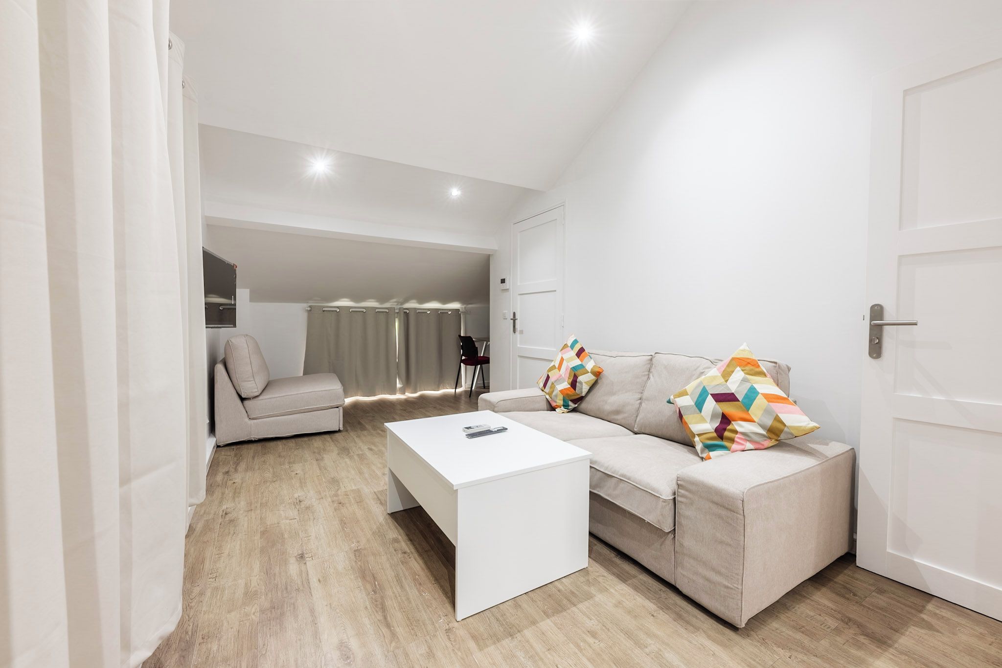Una sala de estar moderna con un sofá, una mesa de centro y una puerta.