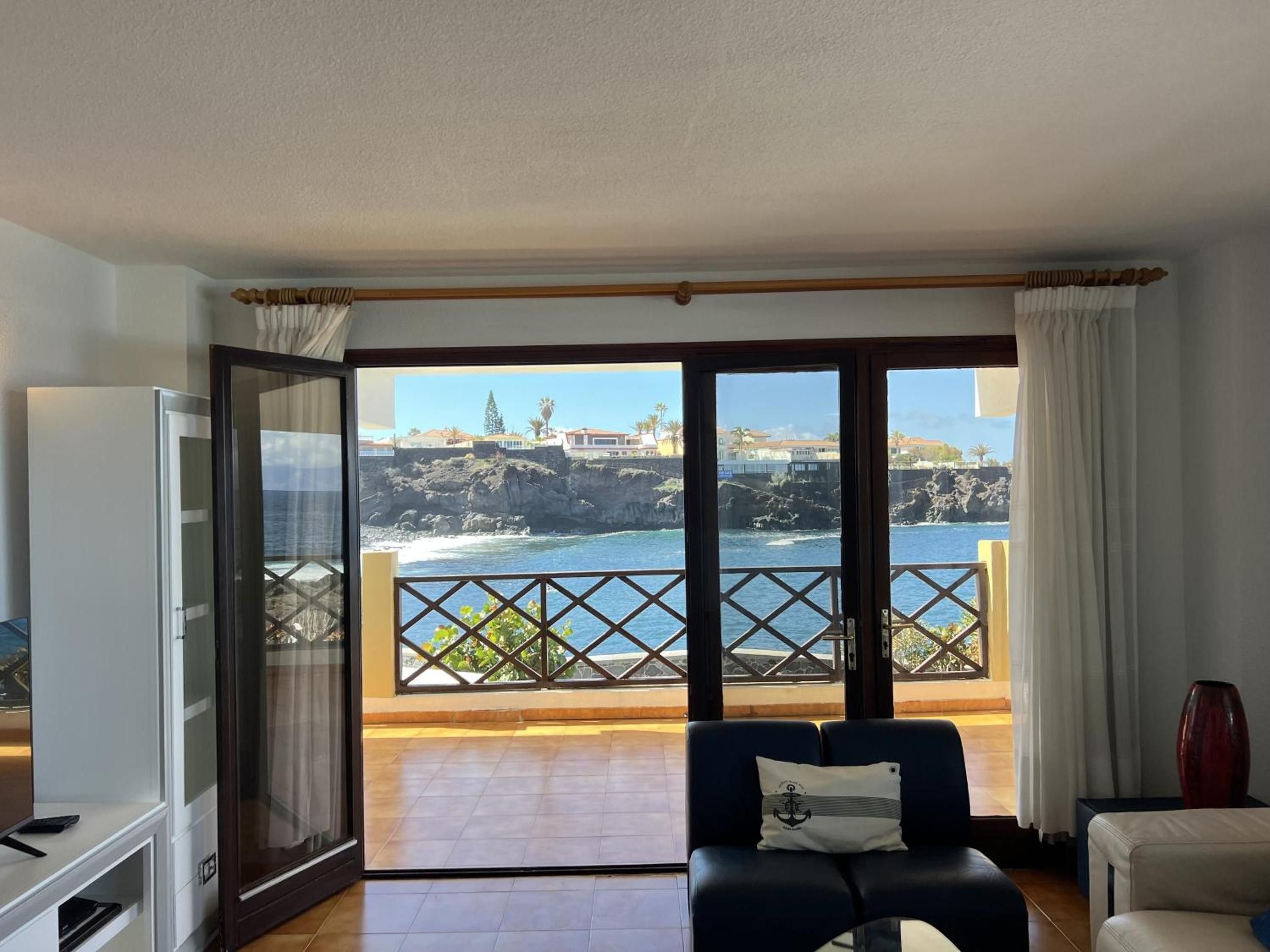 Una habitación con vista al océano y un balcón con barandilla.