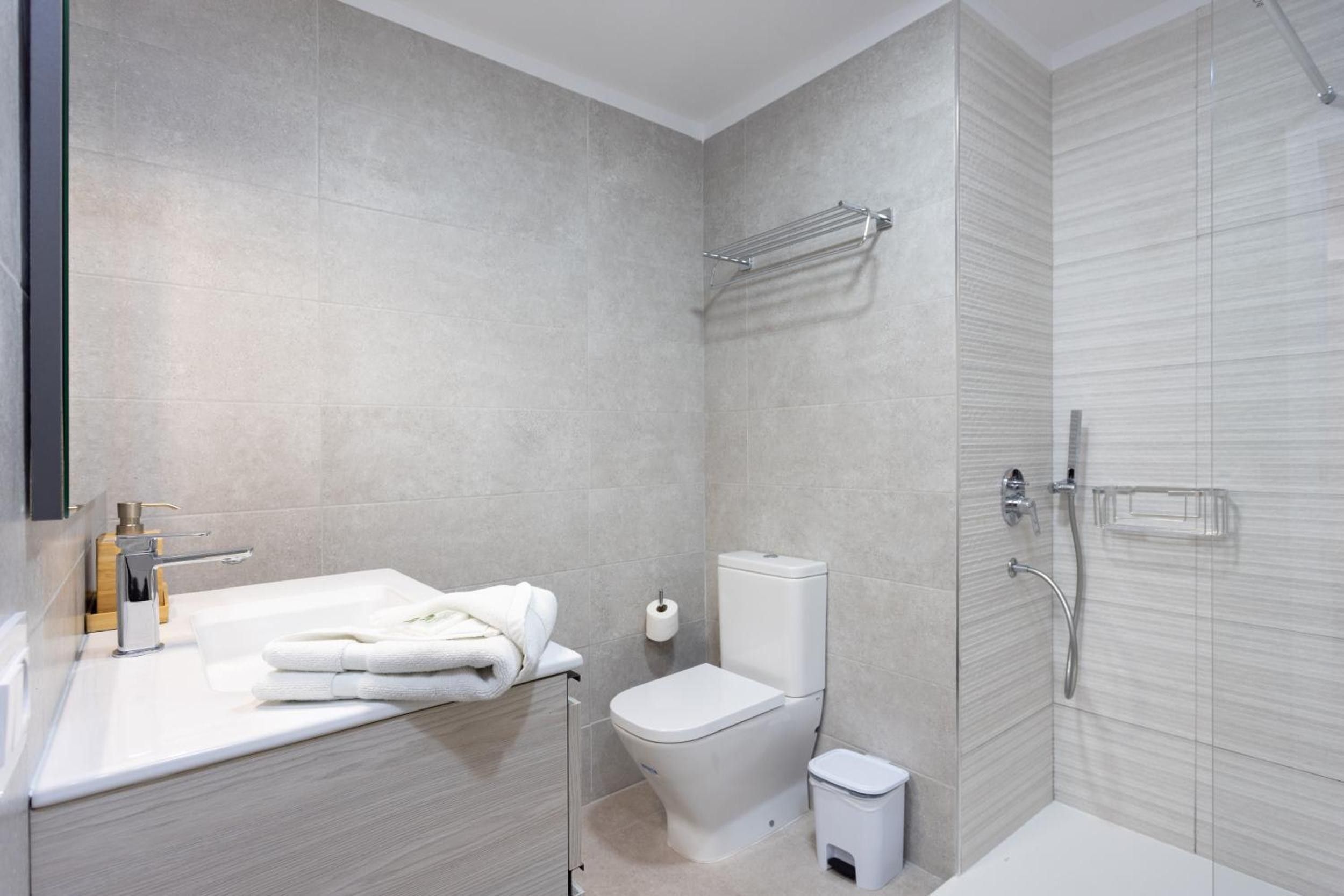 A modern bathroom with a bathtub, toilet, and shower area.