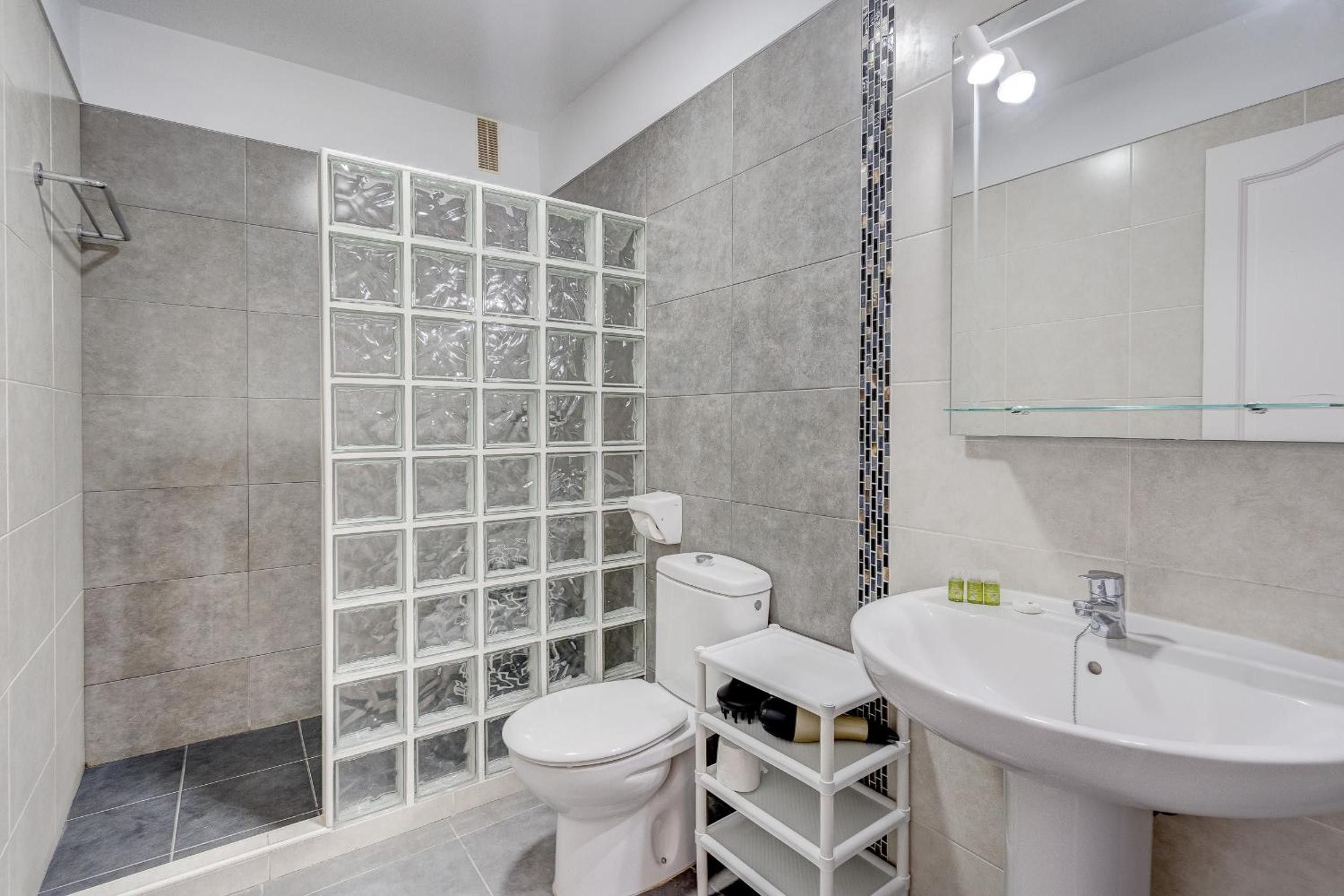 A bathroom with a shower, toilet, and sink.