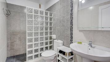 A bathroom with a shower, toilet, and sink.