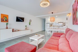 Una sala de estar moderna con un sofá, una mesa de centro y un televisor.