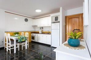 A modern kitchen with white cabinets, a built-in oven, and a refrigerator. - Apartment 'Ático San Juan Teide View By Sydney' with sea view, private terrace and Wi-Fi (Playa San Juan)