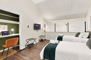 A hotel room with two beds, a desk with a computer, a chair, and a TV on the wall. - Cbus Hub · 2 Kings + Loft  2 twin beds · Sleeps 6 · Private Deck & Grill (Columbus)