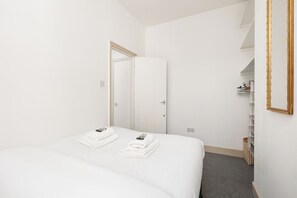 Ein Hotelzimmer mit einem Bett, zwei Handtüchern, einem Kleiderschrank und einem Spiegel.