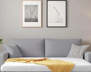 A grey sofa with a white cushion and a yellow throw blanket. - Cody Studio, 25 minutes from Paris CDG, Disneyland, Paris, and the Paris Exhibition Center, (Villeparisis)