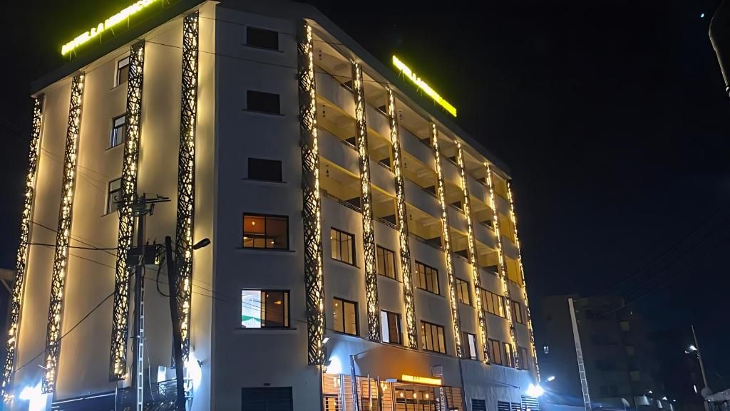 Ein mehrstöckiges Hotel mit Balkonen und einer beleuchteten Fassade bei Nacht.