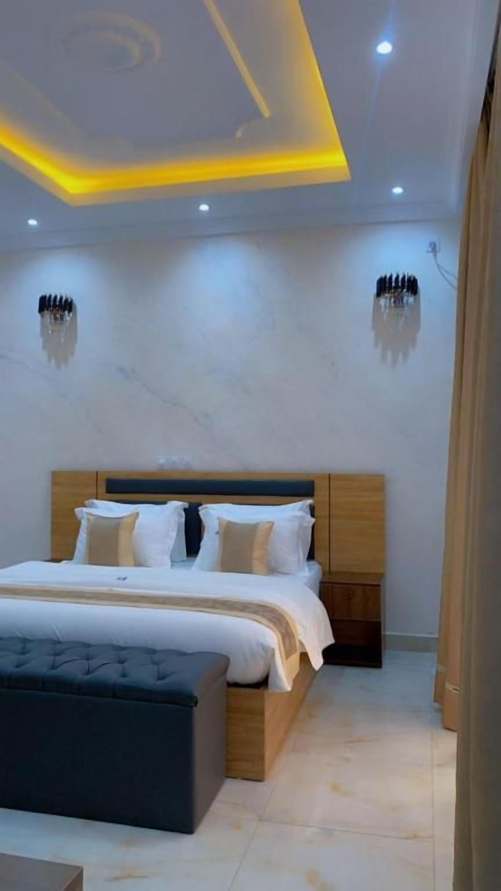 Ein Schlafzimmer mit einem Bett, Nachttischen und einem modernen Deckenstil.