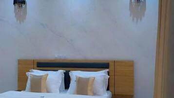 Ein Schlafzimmer mit einem Bett, Nachttischen und einem modernen Deckenstil.