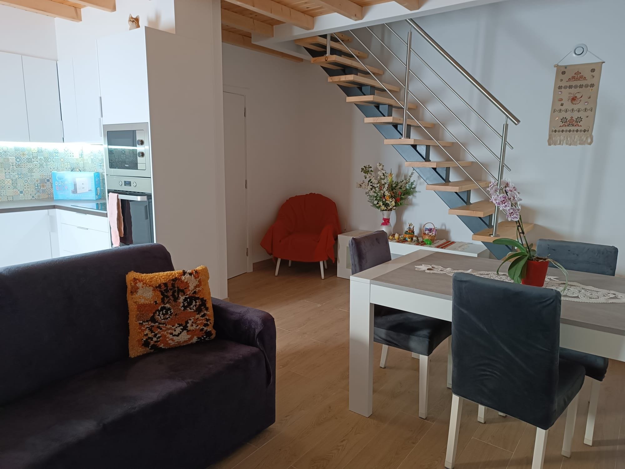 Un espace de vie moderne comprenant un escalier, un coin repas et une cuisine.