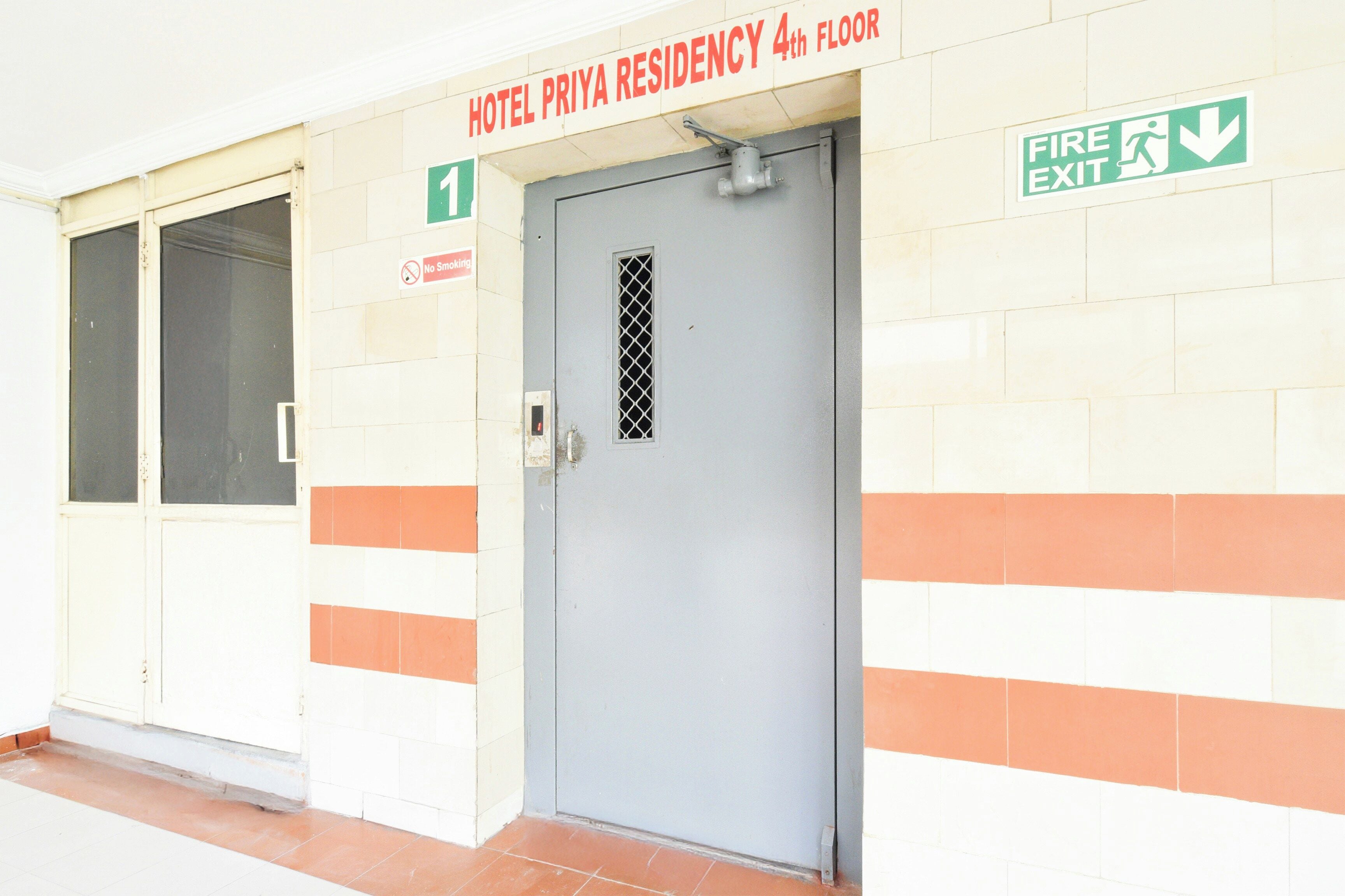 Porta di una residenza alberghiera con un segnale di uscita di sicurezza sopra.