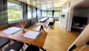 A conference room with a long table, chairs, and a television. - Fasthotel Limoges (Limoges)