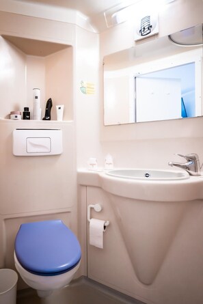 A bathroom with a toilet, sink, and mirror. - Fasthotel Limoges (Limoges)