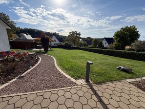 A residential area with a paved walkway, a well-maintained lawn, and houses in the background. - Apartment 'Hawerländer Auszeit' with Private Terrace, Private Garden and Wi-Fi (Schmallenberg)
