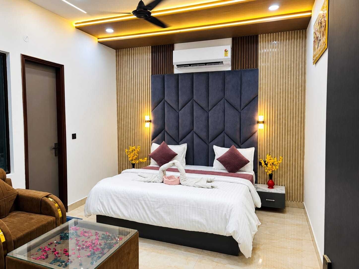 Ein modernes Schlafzimmer mit Bett, Nachttischen, Deckenventilator und Klimaanlage.