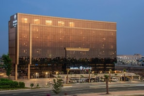 A modern hotel building with a glass facade, a prominent sign, and a well-lit entrance area. - Braira Jazan Hotel (Jizan)