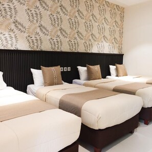 A hotel room with a modern design, featuring a large bed with a headboard, two bedside tables, and a wall with a leaf pattern. - The Tropics at Macarthur Park (Palo)