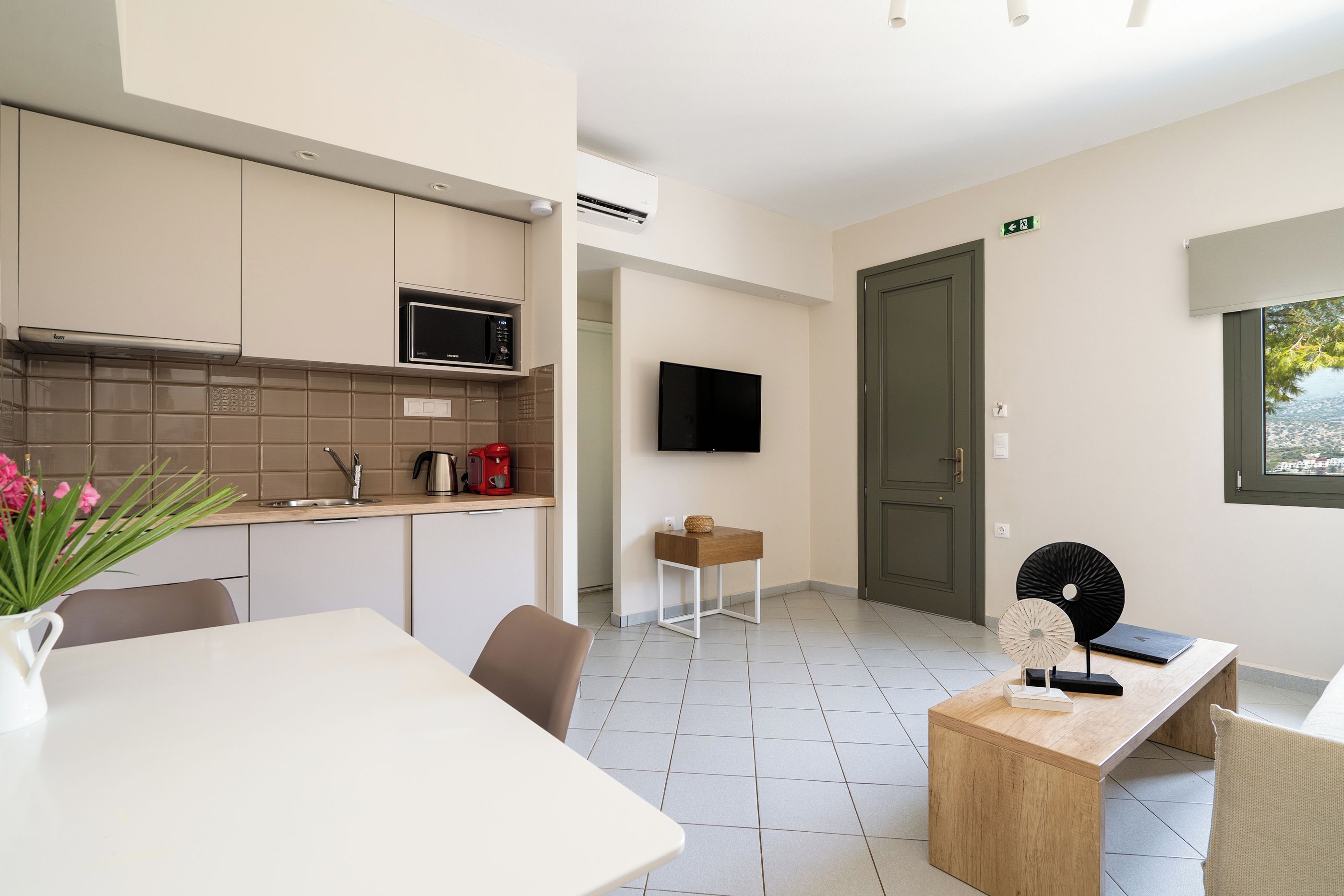 Una cocina moderna con microondas, lavamanos y un comedor con mesa y sillas.
