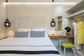 Ein modernes Schlafzimmer mit einem großen Bett, Nachttischen, einer Kommode, einem Spiegel und einer Pendelleuchte.