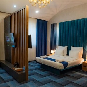 Una habitación de hotel con cama, televisor, cafetera y mesita de noche.