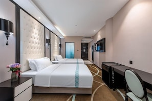 A hotel room with two beds, a desk, a chair, a TV, and a wall-mounted lamp. - Pazhou Xana Deluxe International Hotel (Guangzhou)