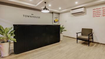 A reception desk with a sign reading 'TOWNHOUSE' and a wall listing floor numbers and room counts.