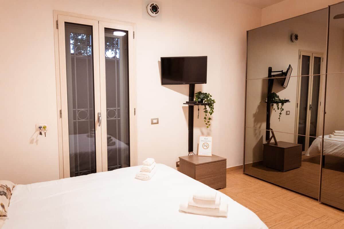 Une chambre d’hôtel équipée d’un lit, d’un téléviseur à écran plat, d’un miroir et d’une armoire.