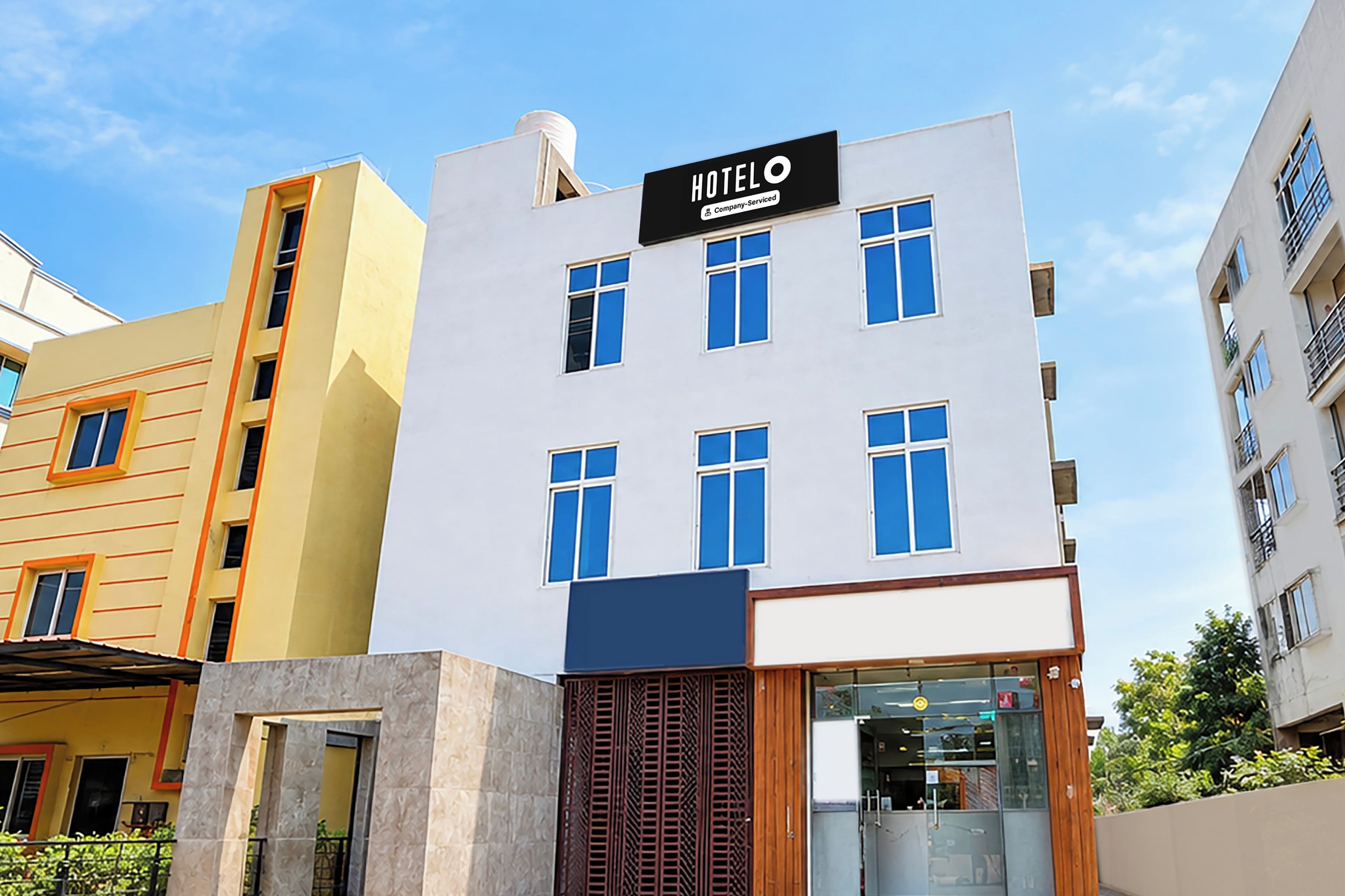 A modern hotel building with a sign indicating it is company-serviced.