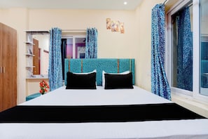 A bedroom with a bed, curtains, a wardrobe, and a window. - Hotel O AIIMS Bhubaneswar Road (Bhubaneshwar)