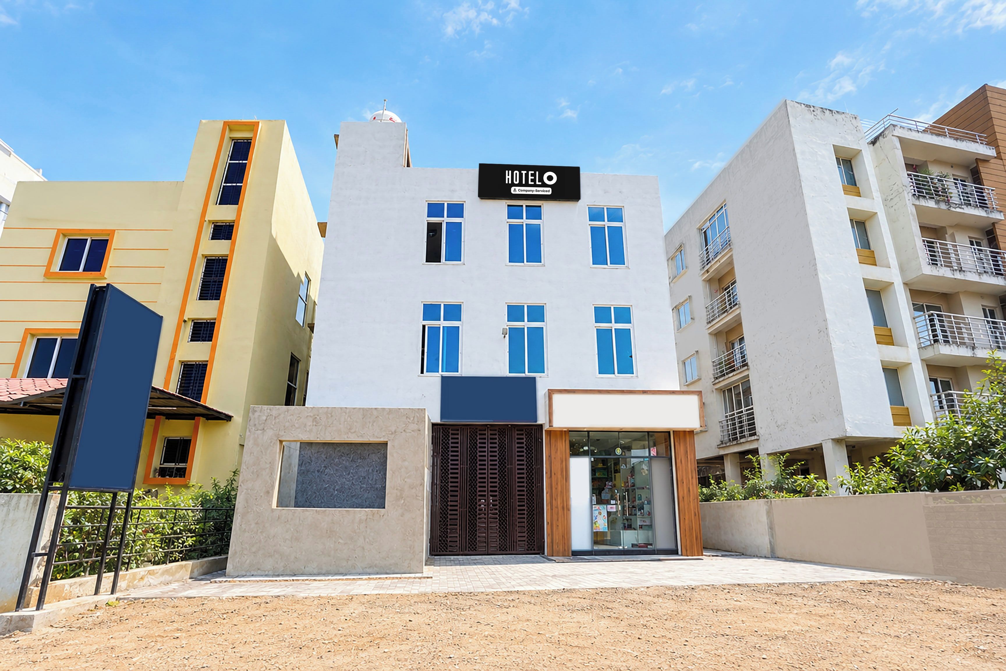 Un hôtel moderne, reconnaissable à son enseigne bien visible, à ses nombreuses fenêtres et à son entrée protégée par un portail.