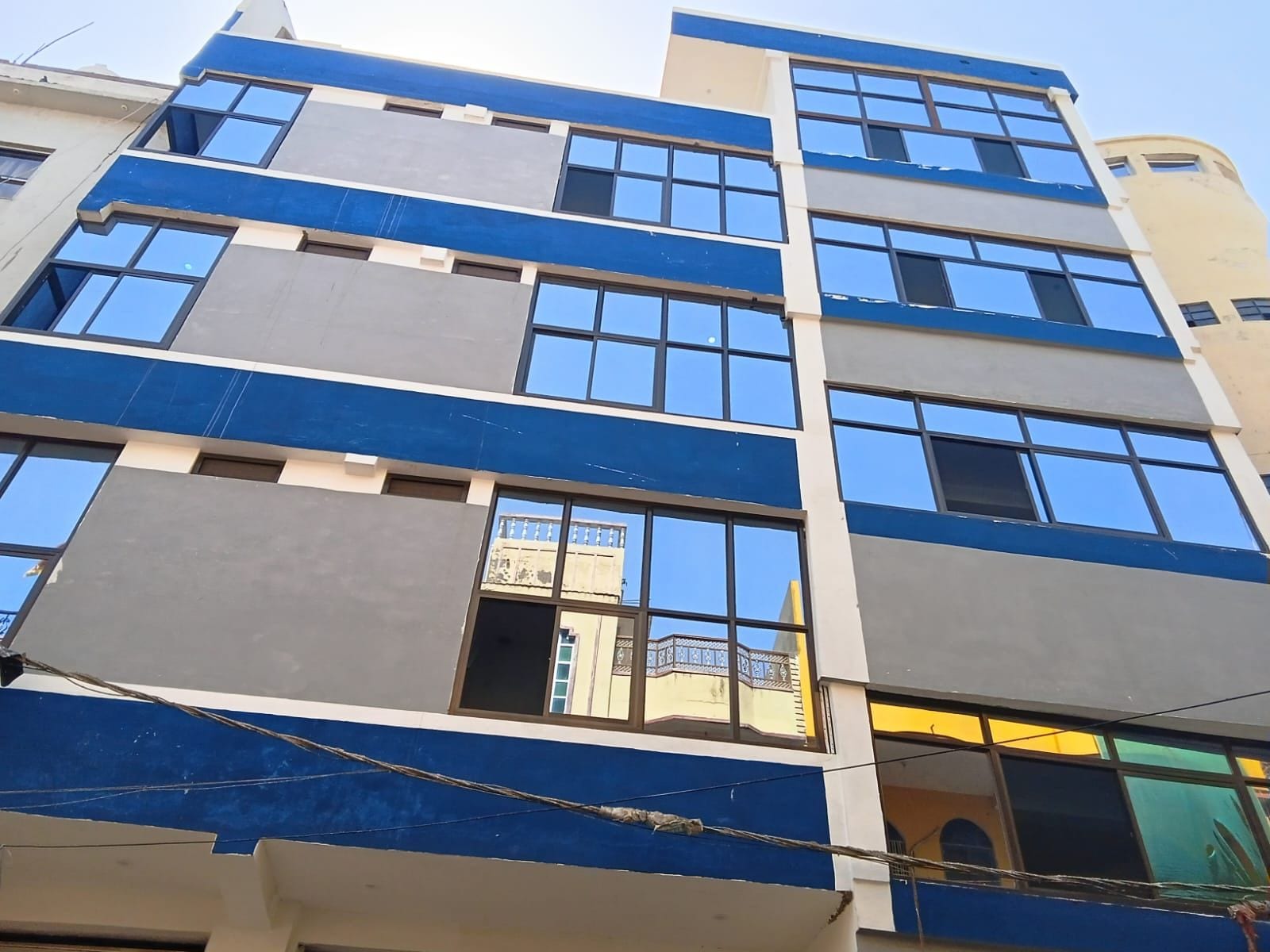 A multi-story building with a modern architectural design, featuring a series of windows and balconies.