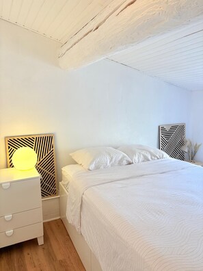 A bedroom with a bed, a bedside table with a lamp, and a wall-mounted artwork. - St Cyprien Cocon in the heart of the village (Saint-Cyprien)