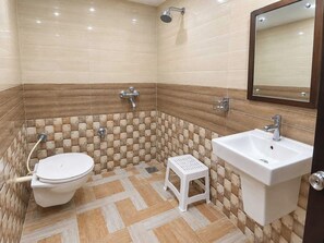 Een badkamer met toilet, wastafel, douche en een spiegel.
