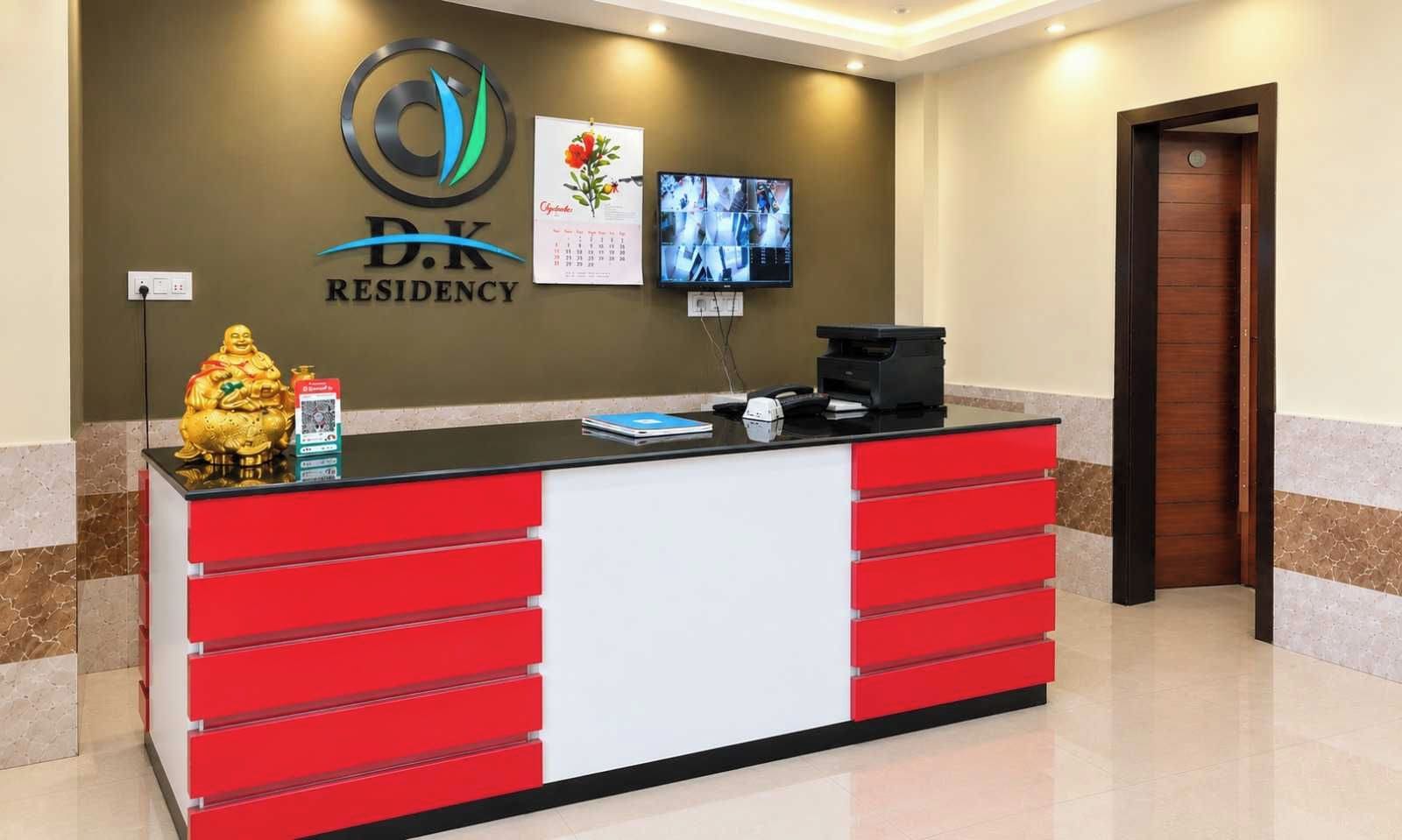 A reception desk with a logo, a calendar, and a television screen.
