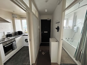 A compact kitchen with a washing machine, a small refrigerator, and a sink. - Central London Studio Apartment- walking distance from the London Eye/Big Ben (London)