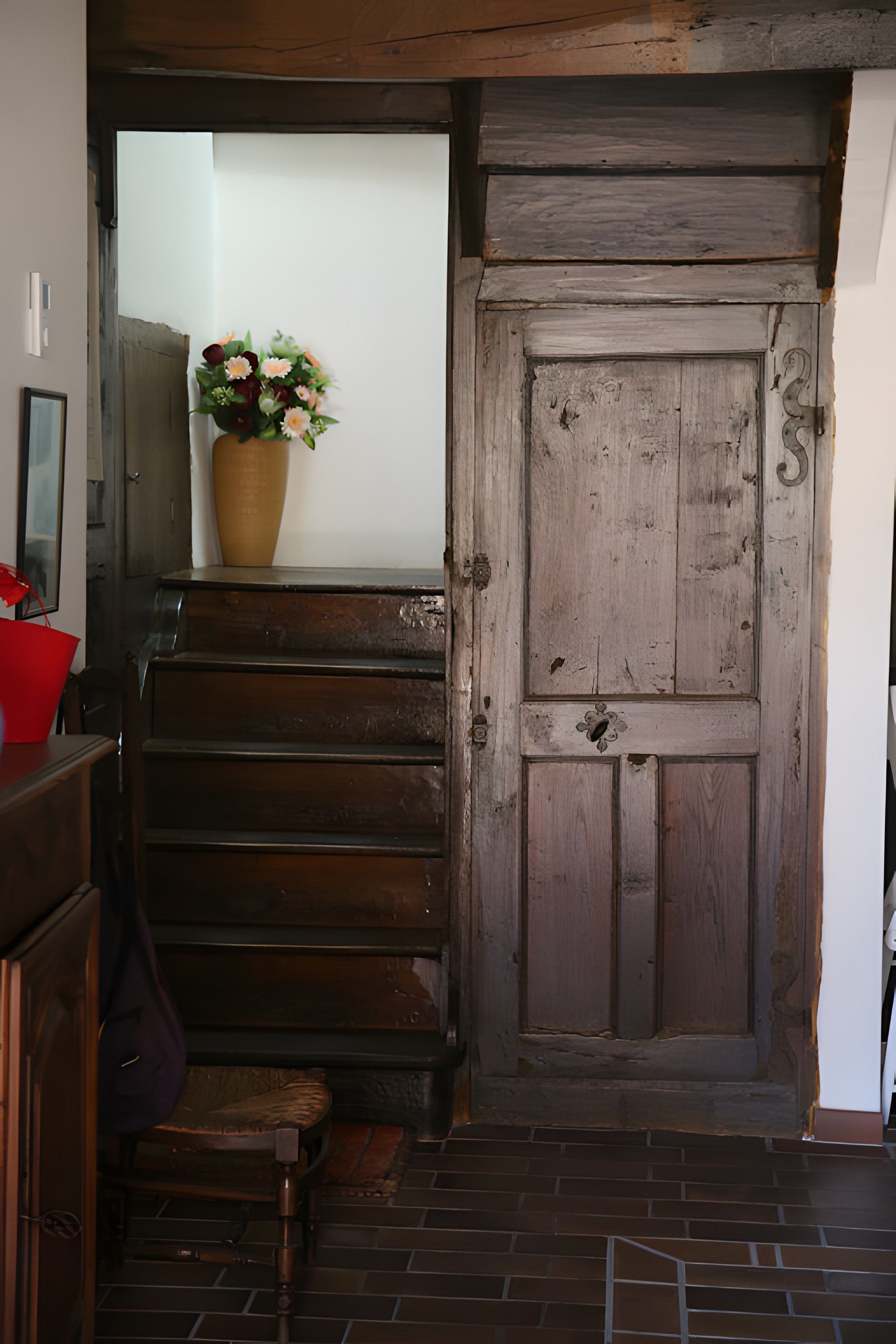 Una escalera de madera que conduce a una puerta con pomo de latón.
