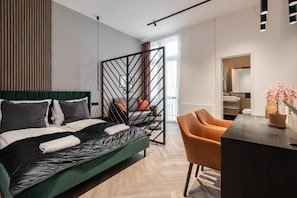 Een moderne slaapkamer met een bed, een bureau en een stoel.