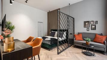 Una habitación moderna con cama, sofá, mesa de comedor y televisor.