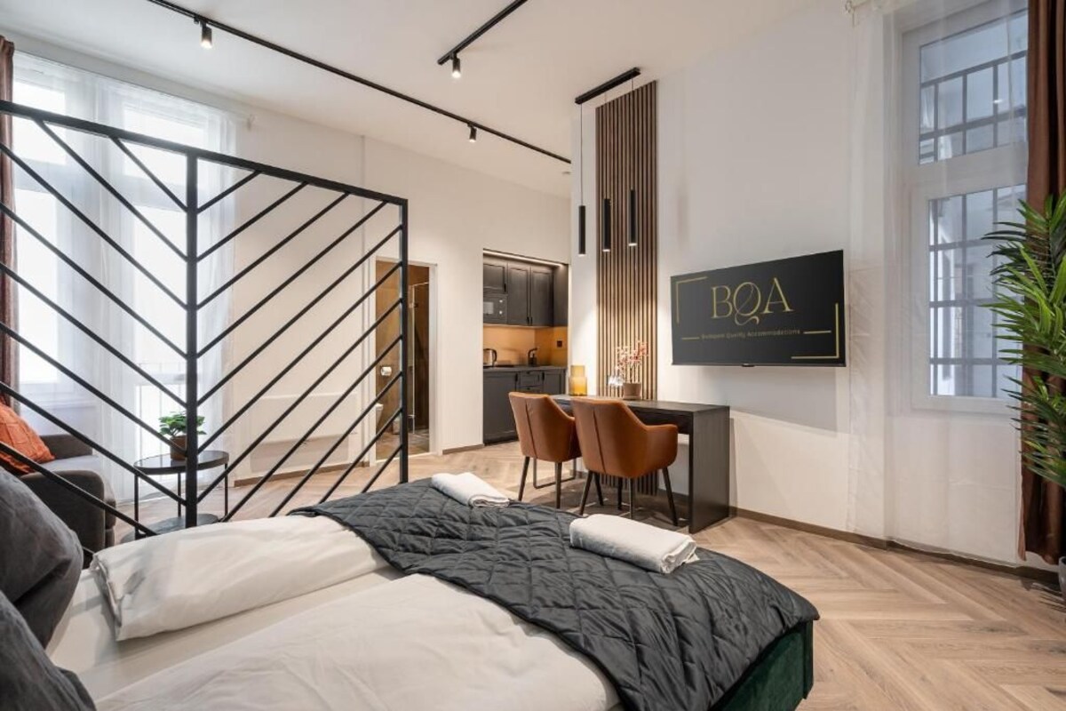 Een moderne hotelkamer met een bed, bureau en televisie.